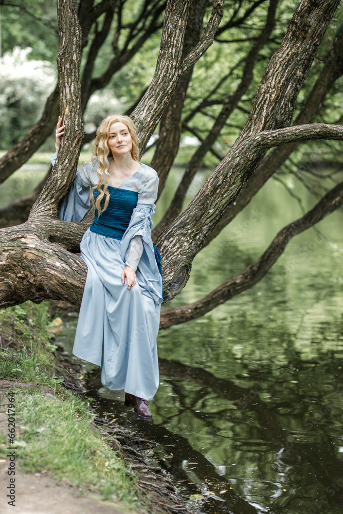 A young beautiful girl in a summer park. A beautiful medieval elf princess in a blue dress in the forest. A young beautiful girl in a summer park. A beautiful medieval elf princess in a blue dress in the forest.