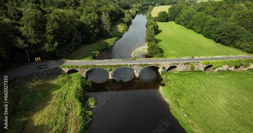 A black car drives over an old stone bridge 4k