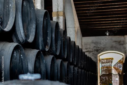 Black wine barrels with wine in winery warehouse