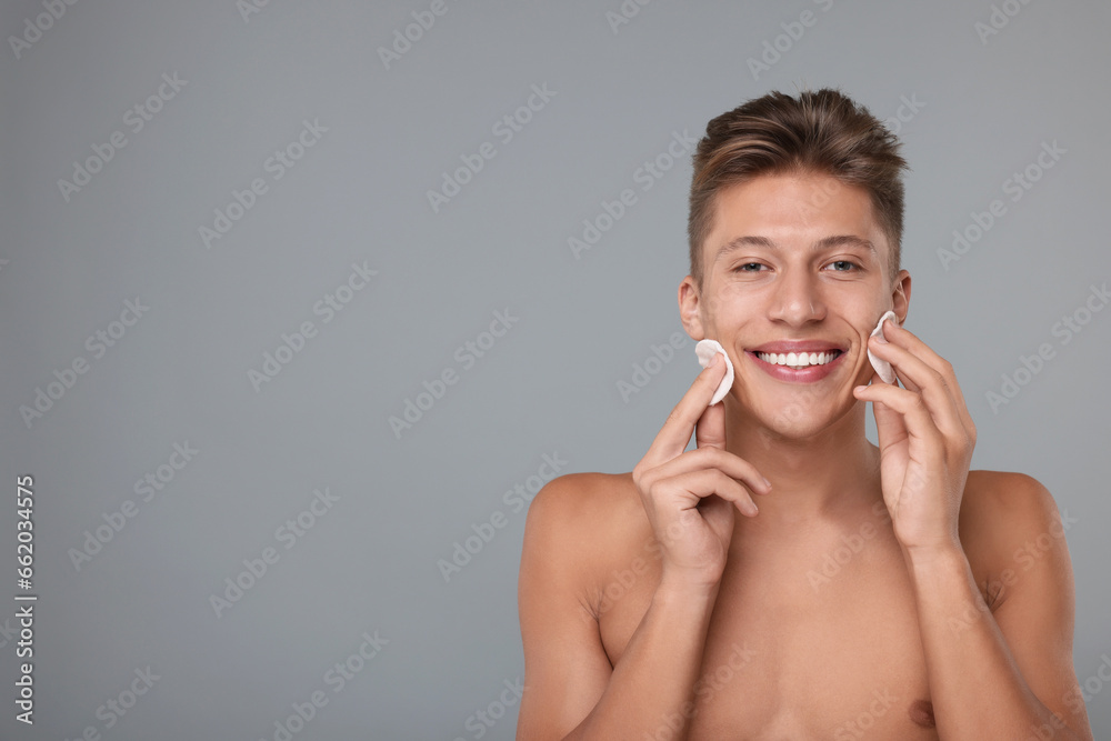 Handsome man with cotton pads on grey background, space for text Handsome man with cotton pads on grey background, space for text