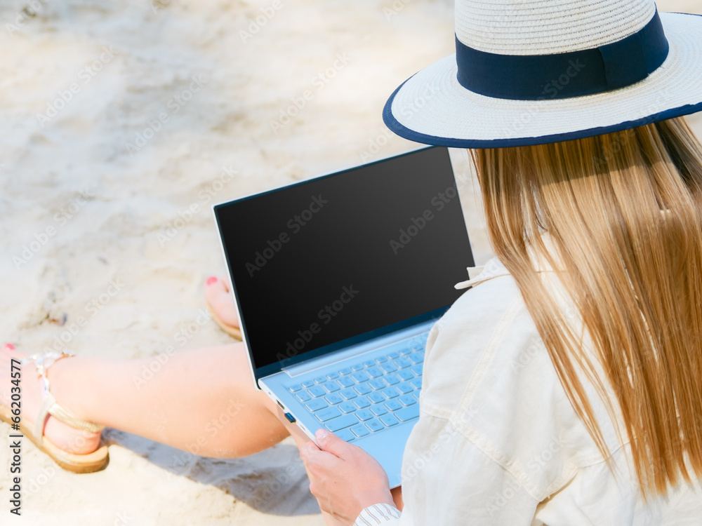 young woman uses laptop computer on the beach. distance work, freelancer and blogger concept. WiFi unlimited
