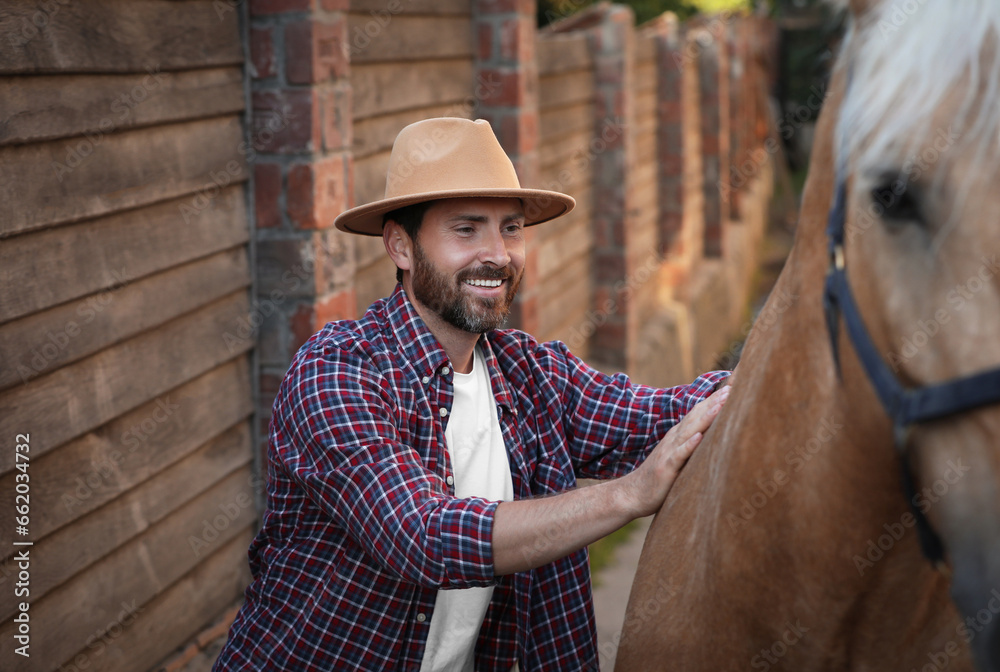 Handsome man with adorable horse outdoors. Lovely domesticated pet