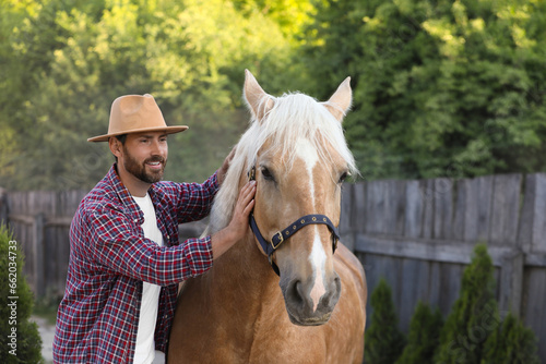 Handsome man with adorable horse outdoors. Lovely domesticated pet