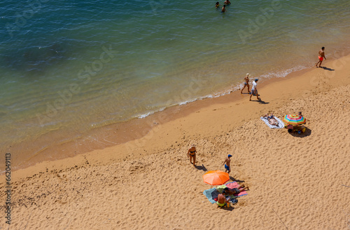Принти на полотні People relax on the beach in New Beach (Praia Nova) in Porches, Lagoa, Algarve,