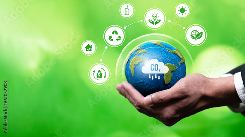 Businessman's hand holding Earth globe symbolize corporate commitment to ESG or CSR to reduce carbon emission and adopting eco-friendly clean business minimizing environmental impact.Panorama Reliance