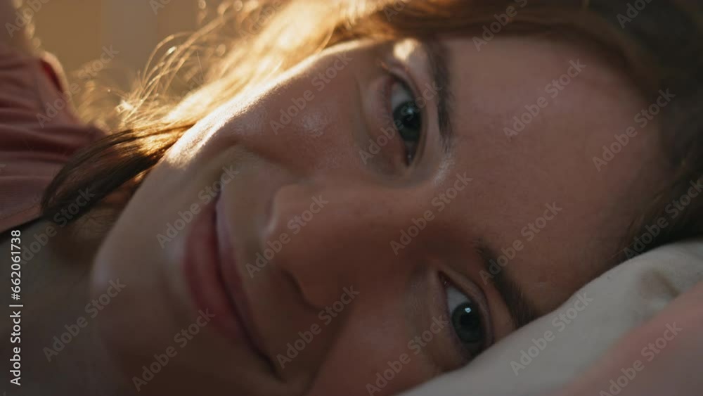 Closeup sleepy girl waking up early morning. Pretty smiling woman resting bed Closeup sleepy girl waking up early morning. Pretty smiling woman resting bed
