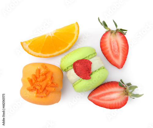 Delicious sweet macarons, strawberries and orange slice isolated on white, top view