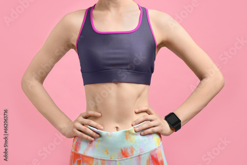 Woman in sportswear on pink background, closeup
