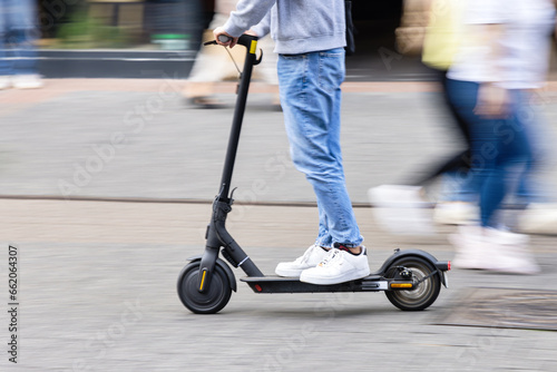 young person with a kick scooter in a pedestrian area
