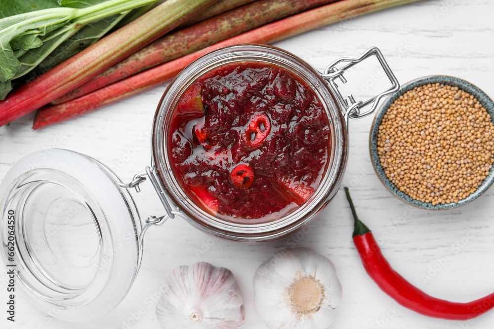 Flat lay composition with tasty rhubarb sauce and ingredients on white wooden table