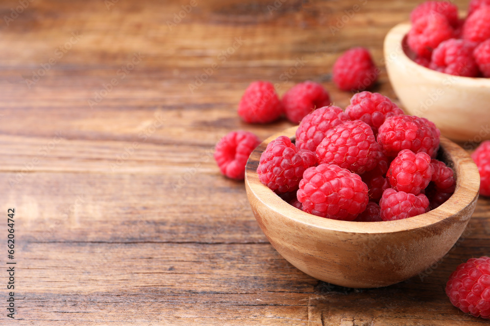 Tasty ripe raspberries on wooden table, space for text Tasty ripe raspberries on wooden table, space for text