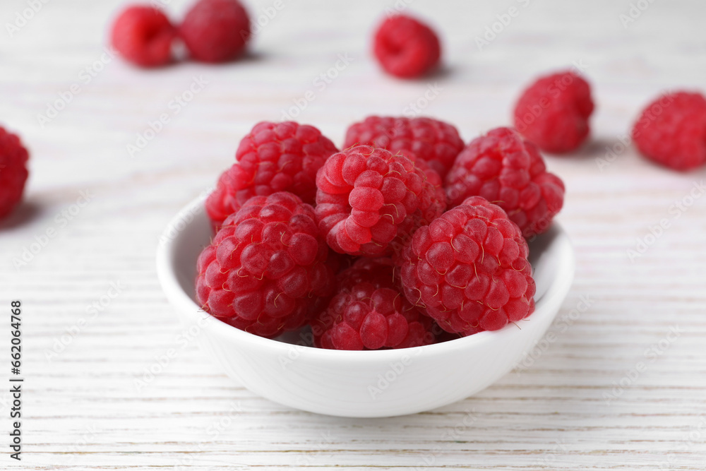 Tasty ripe raspberries in bowl on white wooden table, closeup Tasty ripe raspberries in bowl on white wooden table, closeup