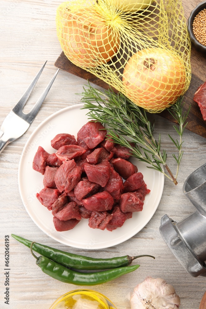 Pieces of beef and products on white wooden table, flat lay Pieces of beef and products on white wooden table, flat lay