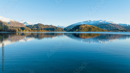 Dawn scenery at Glendhu bay campground looking across Lake Wanaka towards the snow capped mountains in Mt Aspiring National Park