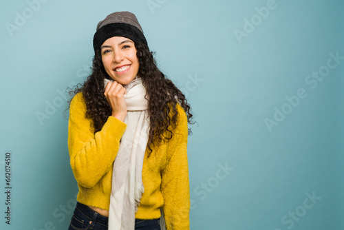 Attractive young woman blowing a kiss with warm winter clothes