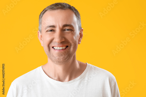Portrait of happy mature man on orange background © Pixel-Shot