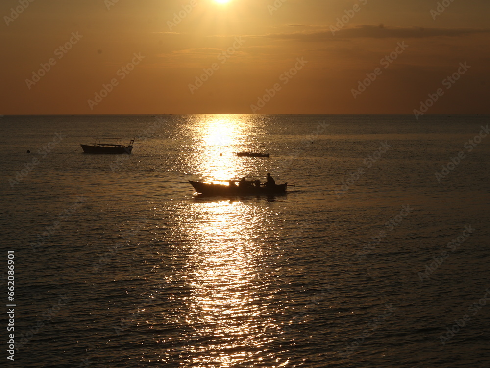Silhouette of a boat in the sea at sunset
