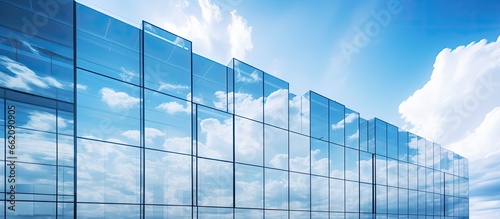 Reflecting clouds in blue sky mirrored by glazing facade and silver aluminum panels