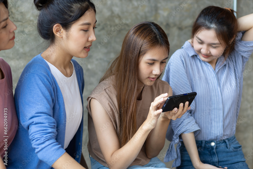 Group of young women using mobile phone. Young people sitting together obsessed with devices online, asian using laptops and smartphones, digital life and gadgets overuse concept. Group of young women using mobile phone. Young people sitting together obsessed with devices online, asian using laptops and smartphones, digital life and gadgets overuse concept.