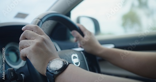 Closeup Hands holding on the Steering Wheel while driving a car, Driving Safety and Automotive Control, Road Trip Adventure