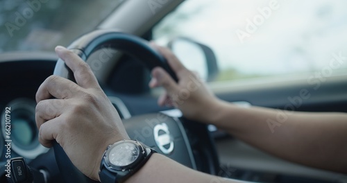 Closeup Hands holding on the Steering Wheel while driving a car, Driving Safety and Automotive Control, Road Trip Adventure