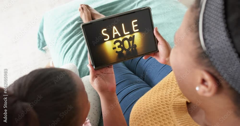African american mother and daughter using tablet, shopping online during sale, slow motion African american mother and daughter using tablet, shopping online during sale, slow motion
