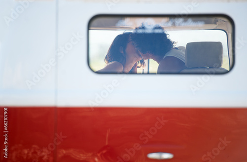 Caravan, transportation and couple kiss on road trip, travel and vacation with people in relationship and commitment. Love, intimacy with window and freedom on adventure together, transport and date