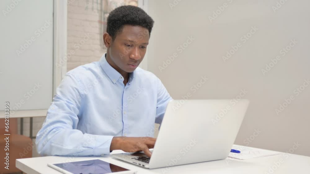 African Businessman Working on Laptop in Office African Businessman Working on Laptop in Office