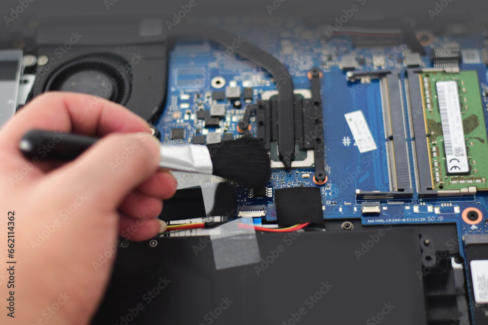 omputer technician Laptop motherboard repairman is using a converter to clean the motherboard. omputer technician Laptop motherboard repairman is using a converter to clean the motherboard.