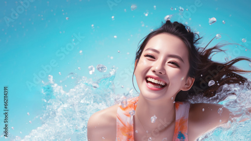 Smiling chinese woman wearing swimsuit playing water splash © pariketan