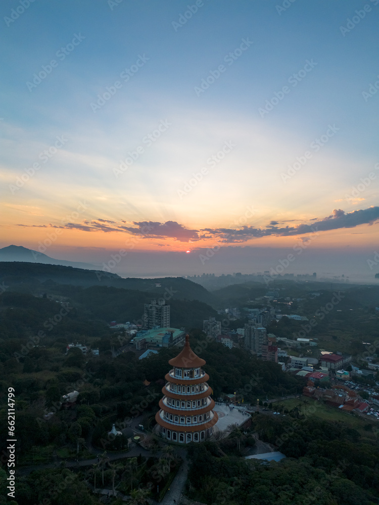 Naklejka premium Aerial view of sunset at Wuji Tianyuan Temple by drone in Tamsui, New Taipei City, Taiwan. Beautiful weather, blue sky and mountains.
