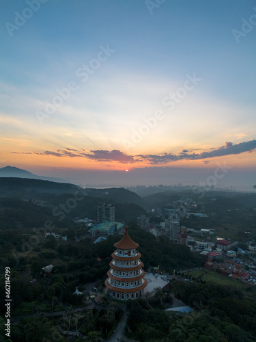 Aerial view of sunset at Wuji Tianyuan Temple by drone in Tamsui, New Taipei City, Taiwan. Beautiful weather, blue sky and mountains.