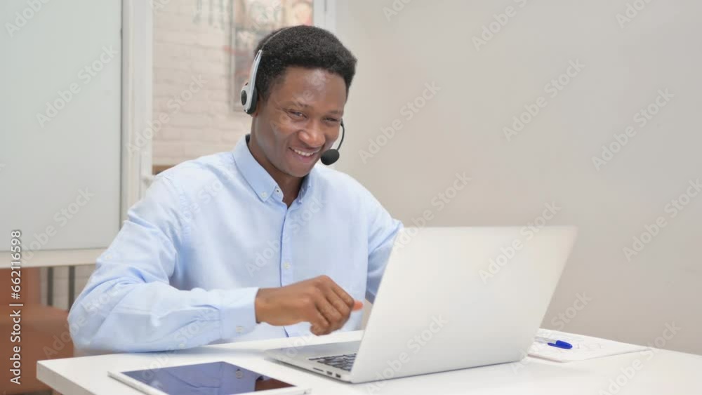 Thumbs Up by African Man with Headset Using Laptop in Call Center Thumbs Up by African Man with Headset Using Laptop in Call Center