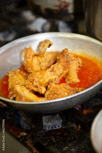 A view of chicken wings cooking in a pan.