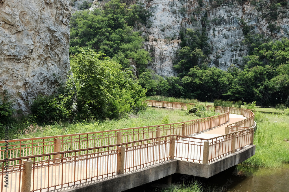 Beautiful walkway wooden bridge for lake with rocky mountain view at Khao ngoo national park, Ratchaburi, Thailand Beautiful walkway wooden bridge for lake with rocky mountain view at Khao ngoo national park, Ratchaburi, Thailand