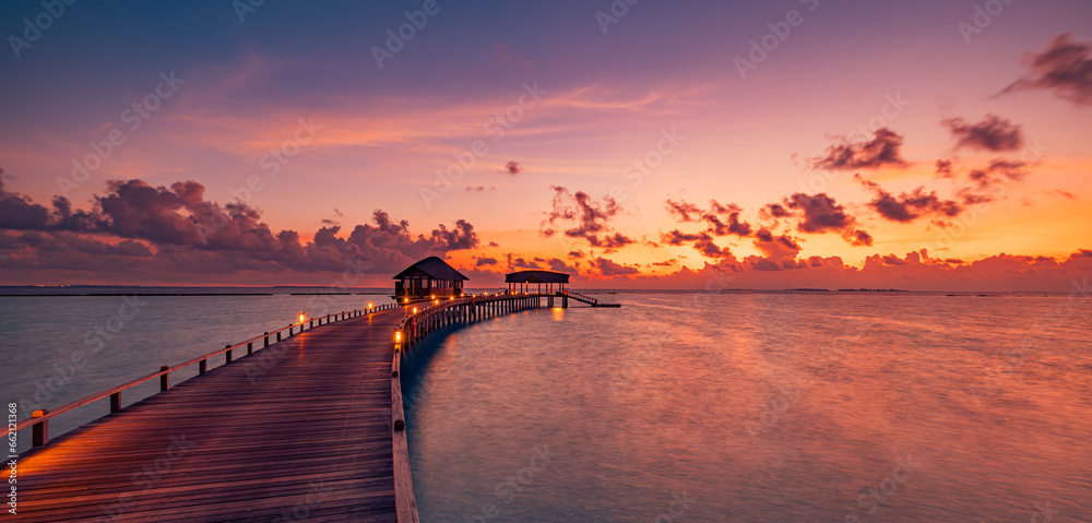 Amazing sunset panorama Maldives. Luxury resort villas pier path seascape soft led lights under colorful sky. Beautiful twilight sky fantastic clouds. Majestic beach background best vacation holiday - obrazy, fototapety, plakaty 