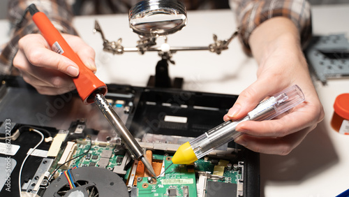 a master with a soldering iron soldering a chip