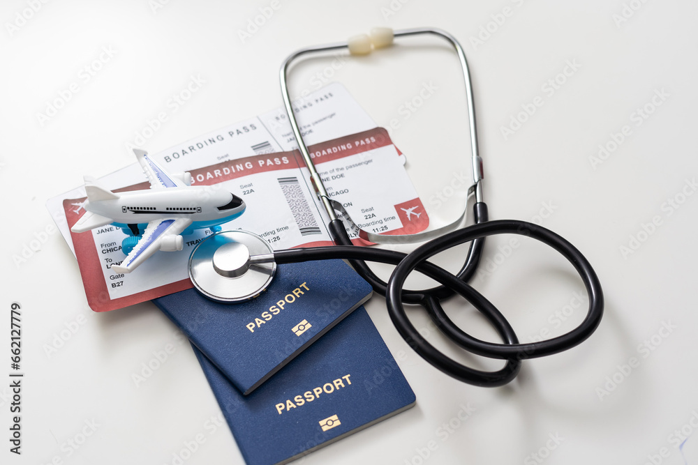 health insurance in travel concept. medical care abroad. stethoscope, toy airplane and passports - obrazy, fototapety, plakaty 