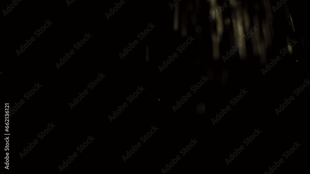 Many particles on a black background. Heavy rain illuminated by flickering light. Video is suitable for your projects and spectacular transitions.