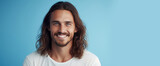 Handsome elegant sexy smiling Caucasian man with perfect skin and long hair, on a light blue background, banner, close-up.