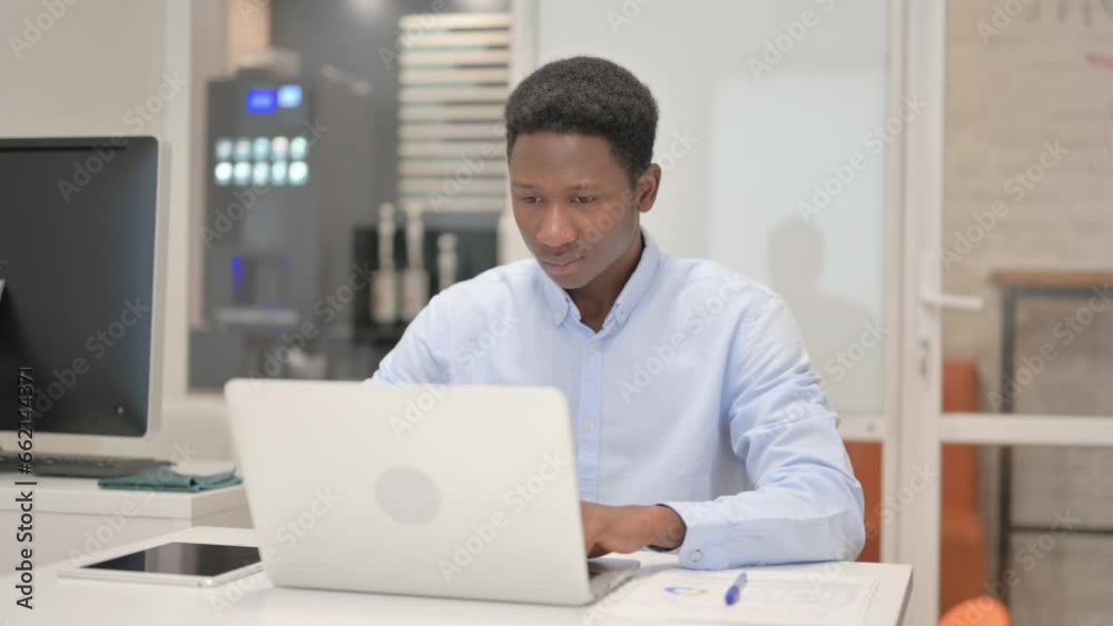 African Businessman Working on Laptop in Office African Businessman Working on Laptop in Office