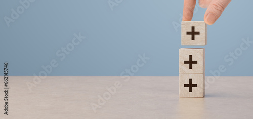 Bild auf Leinwand Plus sign in wooden cubes stacking
