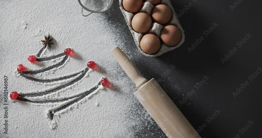 Video of christmas tree drawn in flour, eggs, roler and copy space on black background Video of christmas tree drawn in flour, eggs, roler and copy space on black background