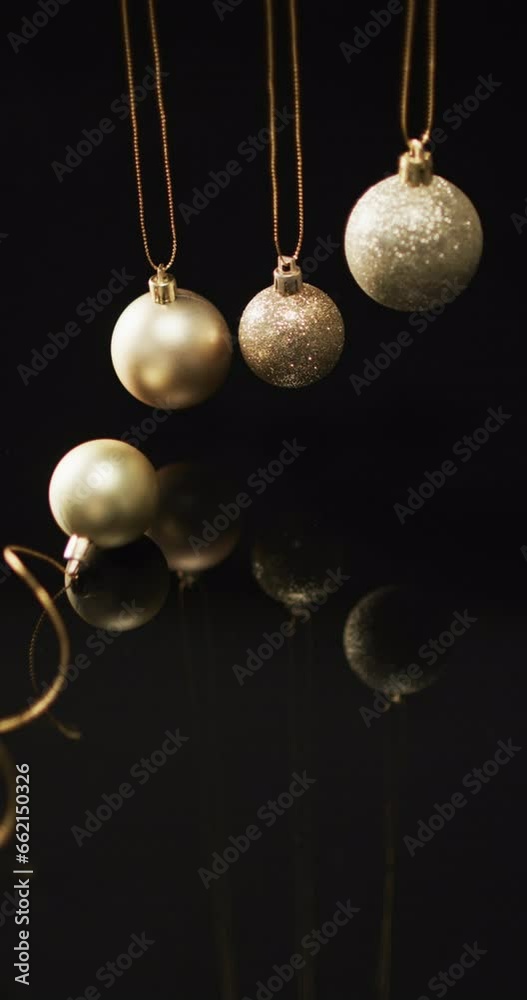 Vertical video of gold baubles christmas decorations and copy space on black background Vertical video of gold baubles christmas decorations and copy space on black background
