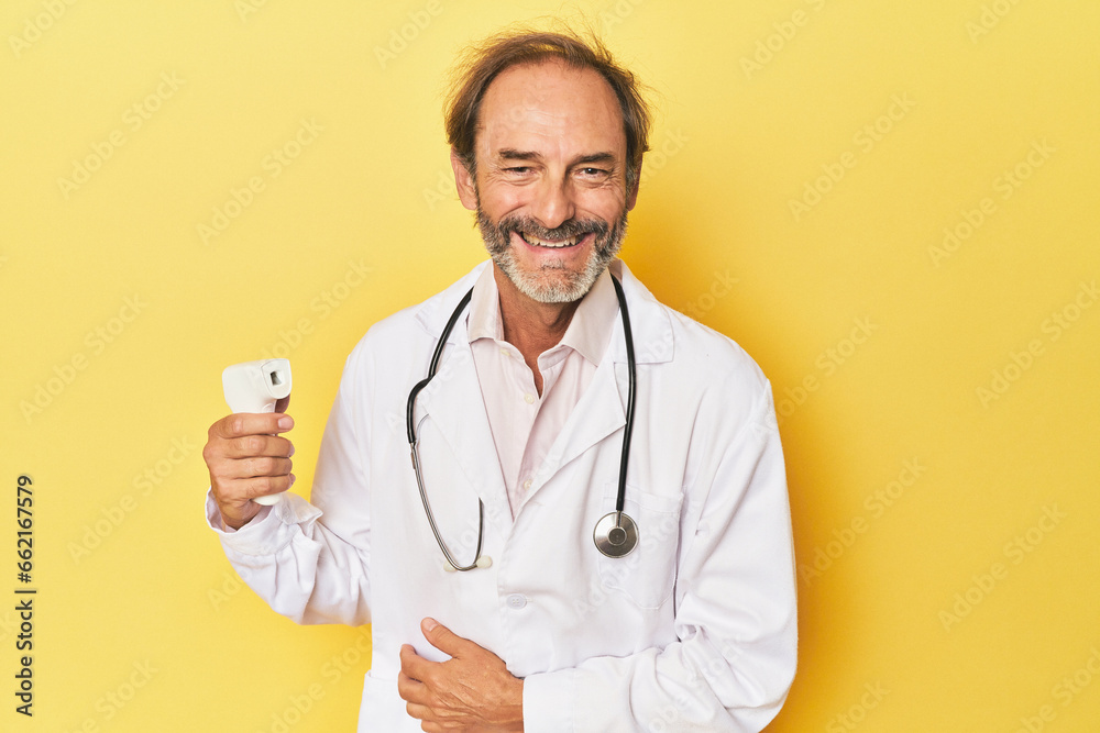 Doctor holding infrared thermometer in studio laughing and having fun. Doctor holding infrared thermometer in studio laughing and having fun.