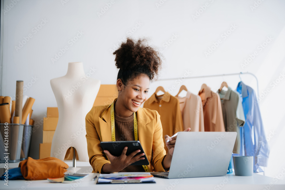 Diverse female fashion designers at work with tailor centimeters on necks and holds tablet and smartphone. independent creative design - obrazy, fototapety, plakaty 