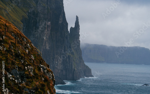 Trollkonufingur rock, also called The Witch's Finger on the island of Vagar. Trollkonufingur is a freestanding sea stack rock on the east of Sandavagur village on the Faroe Islands.