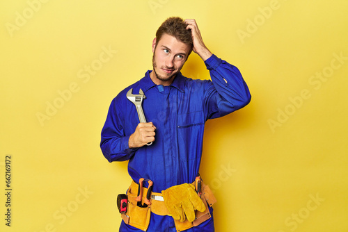 Technician in blue jumpsuit with tools on yellow being shocked, she has remembered important meeting.