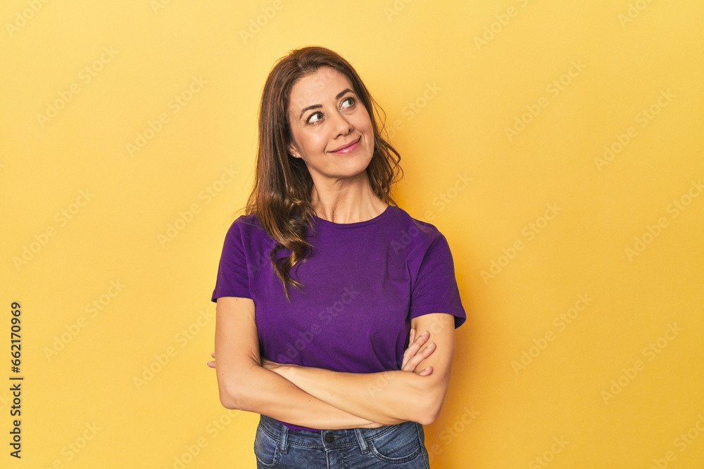 Fototapeta premium Middle-aged caucasian woman on yellow dreaming of achieving goals and purposes