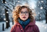 Portrait of cute little girl with glasses and curly hair isolated on winter snowy background, people banner with copy space text 